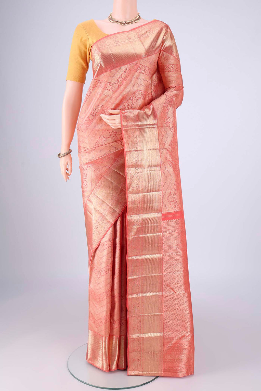 Peach Kanchipuram Silk Saree with Zari Brocade on the body and Zari Border.  displayed on a mannequin