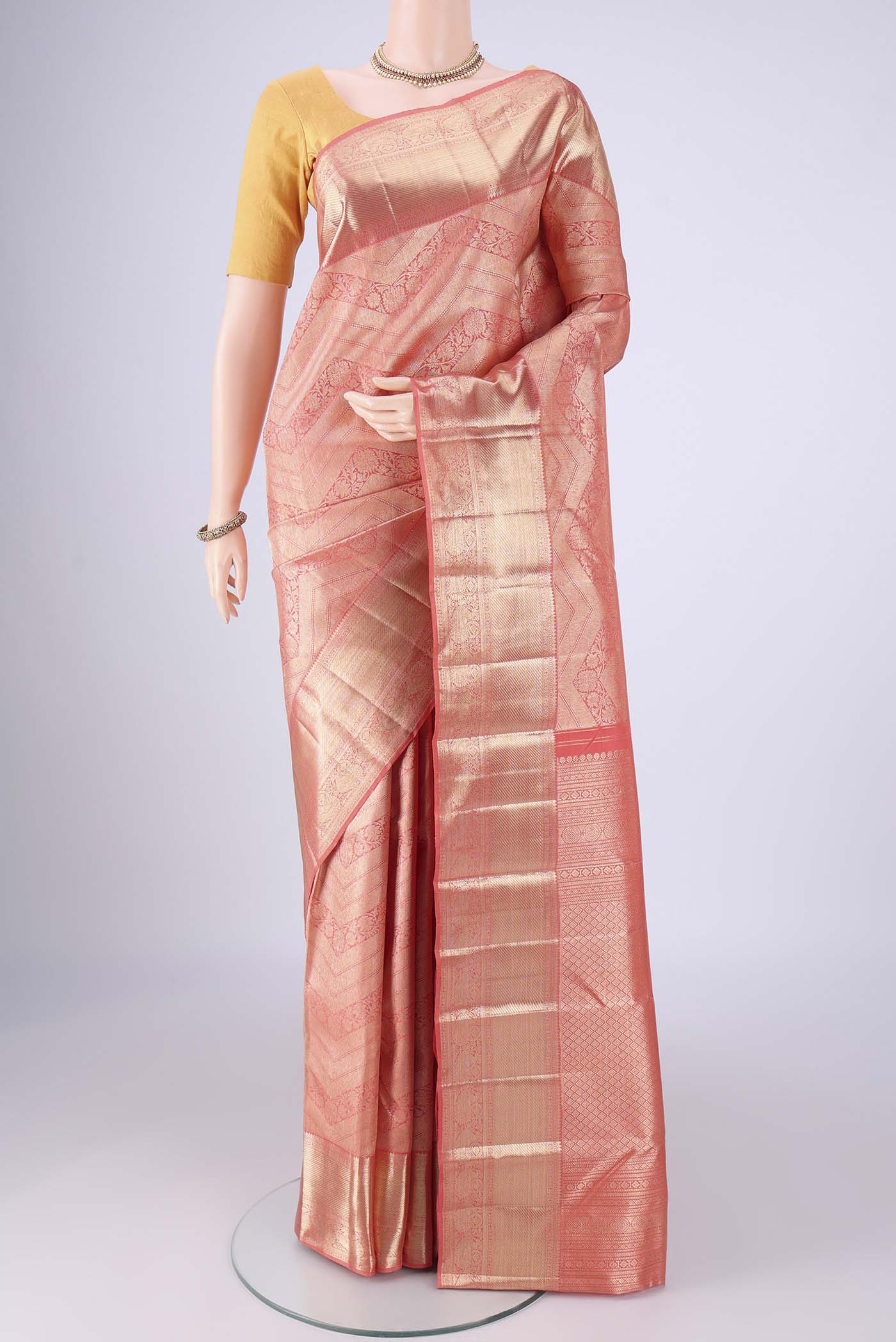 Peach Kanchipuram Silk Saree with Zari Brocade on the body and Zari Border.  displayed on a mannequin