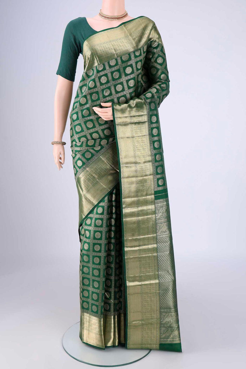Bottle Green Kanchipuram Silk Saree with Zari Brocade on the body and Zari Border.  displayed on a mannequin