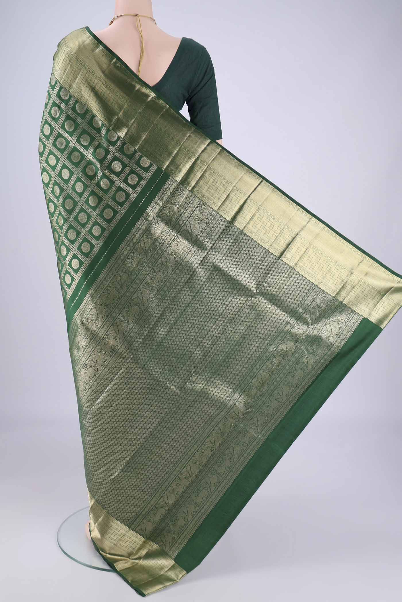 Flat view of Bottle Green Kanchipuram Silk Saree with Zari Brocade on the body and Zari Border. 