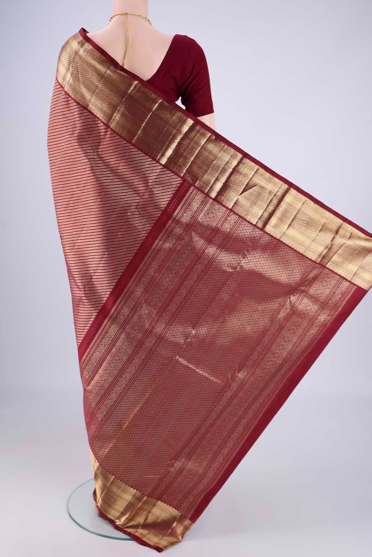 Flat view of Maroon Kanchipuram Silk Saree with Zari Brocade on the body and Zari Border. 