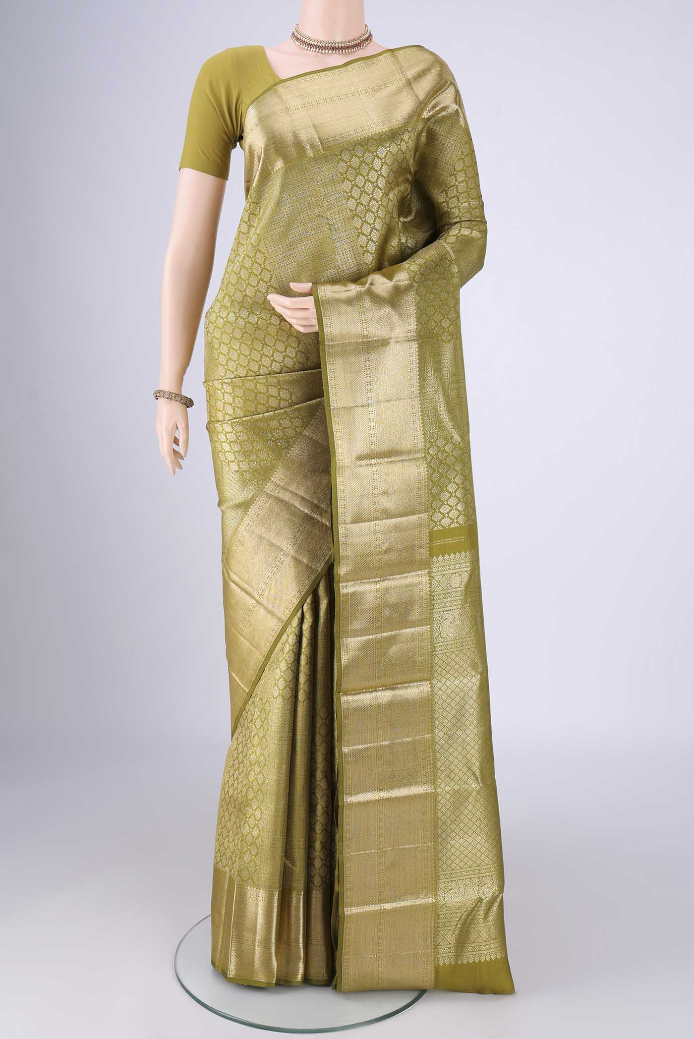 Mehandi Green Kanchipuram Silk Saree with Zari Brocade on the body and Zari Border.  displayed on a mannequin