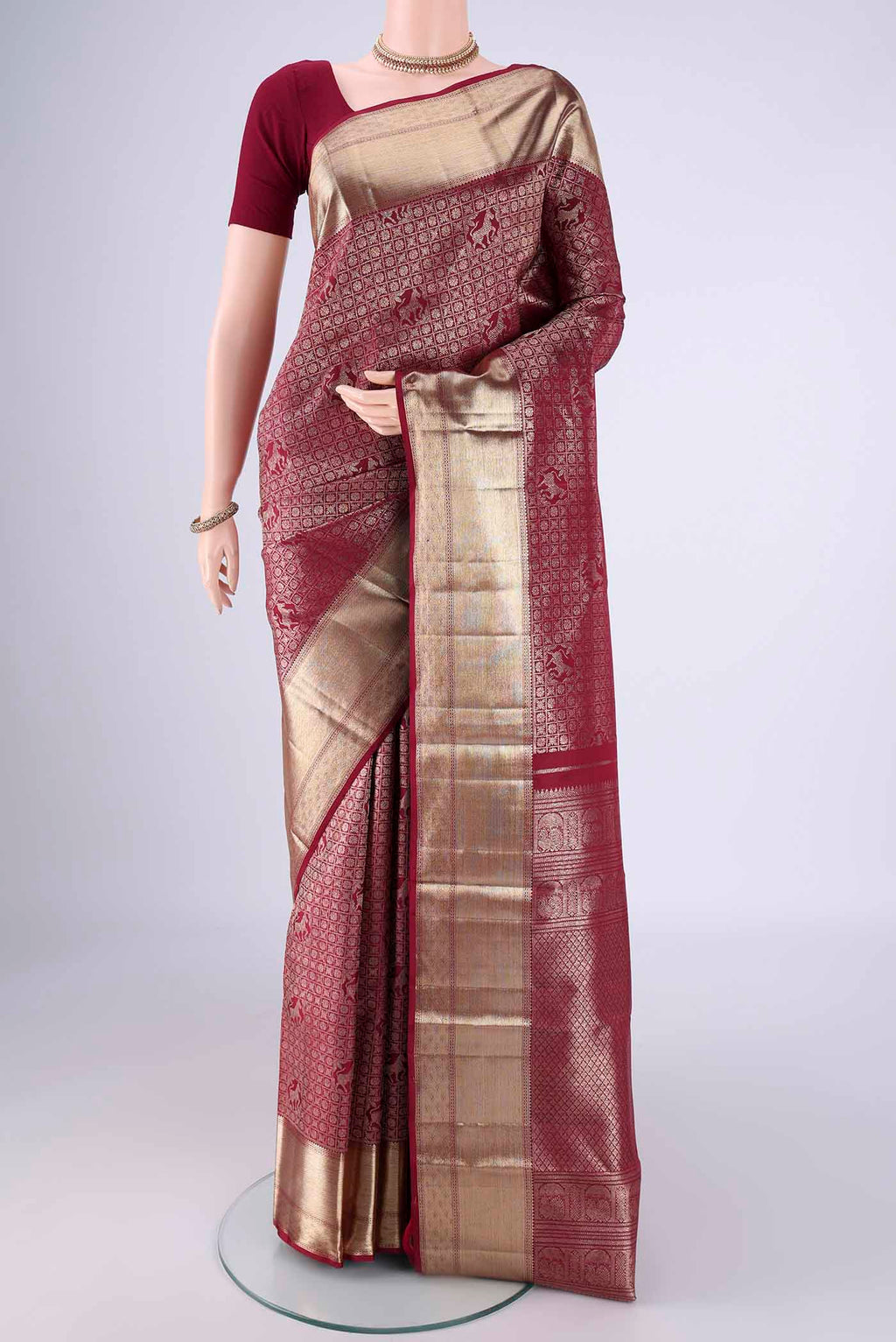 Maroon Kanchipuram Silk Saree with Zari Brocade on the body and Zari Border.  displayed on a mannequin