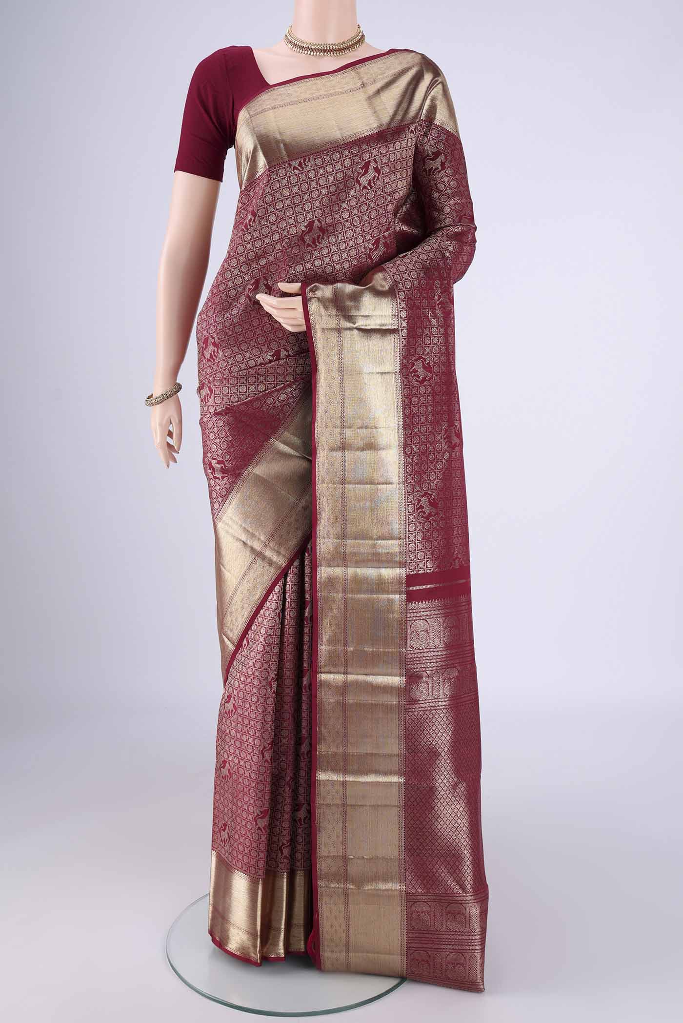 Maroon Kanchipuram Silk Saree with Zari Brocade on the body and Zari Border.  displayed on a mannequin