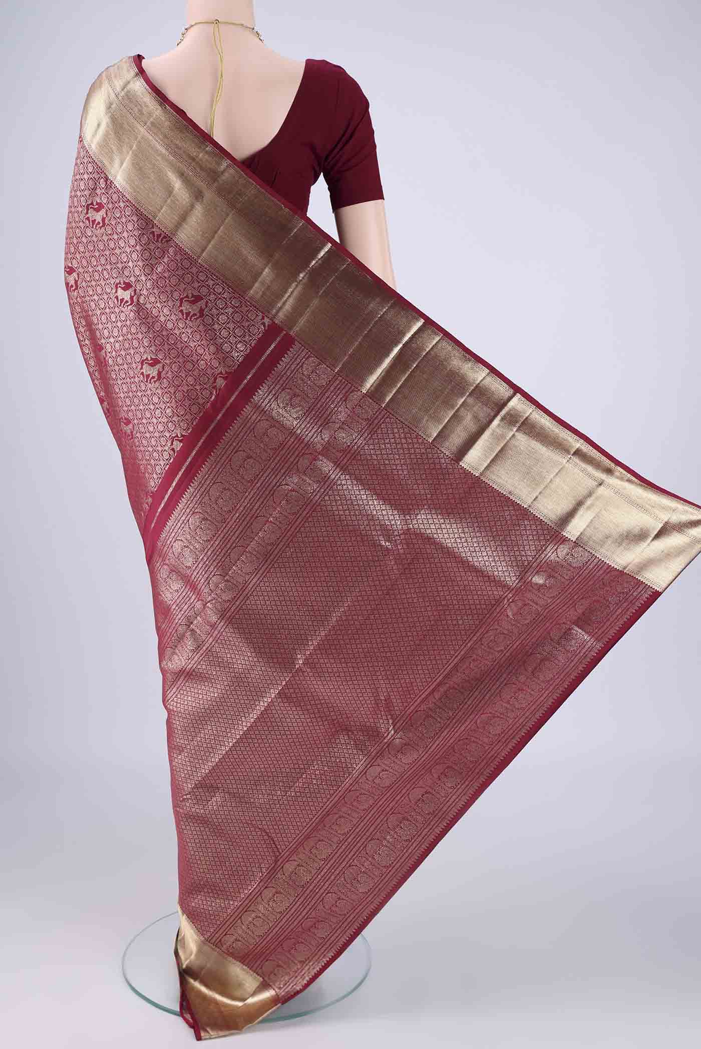 Flat view of Maroon Kanchipuram Silk Saree with Zari Brocade on the body and Zari Border. 