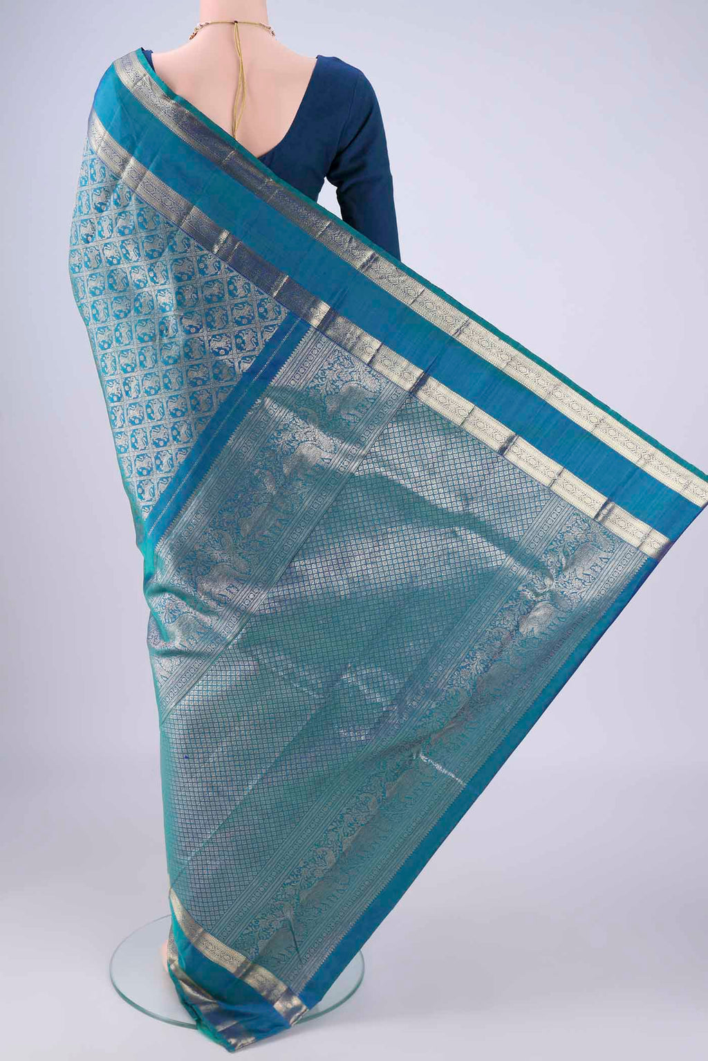 Flat view of Peacock Blue Kanchipuram Silk Saree with Zari Brocade on the body and Zari Border. 