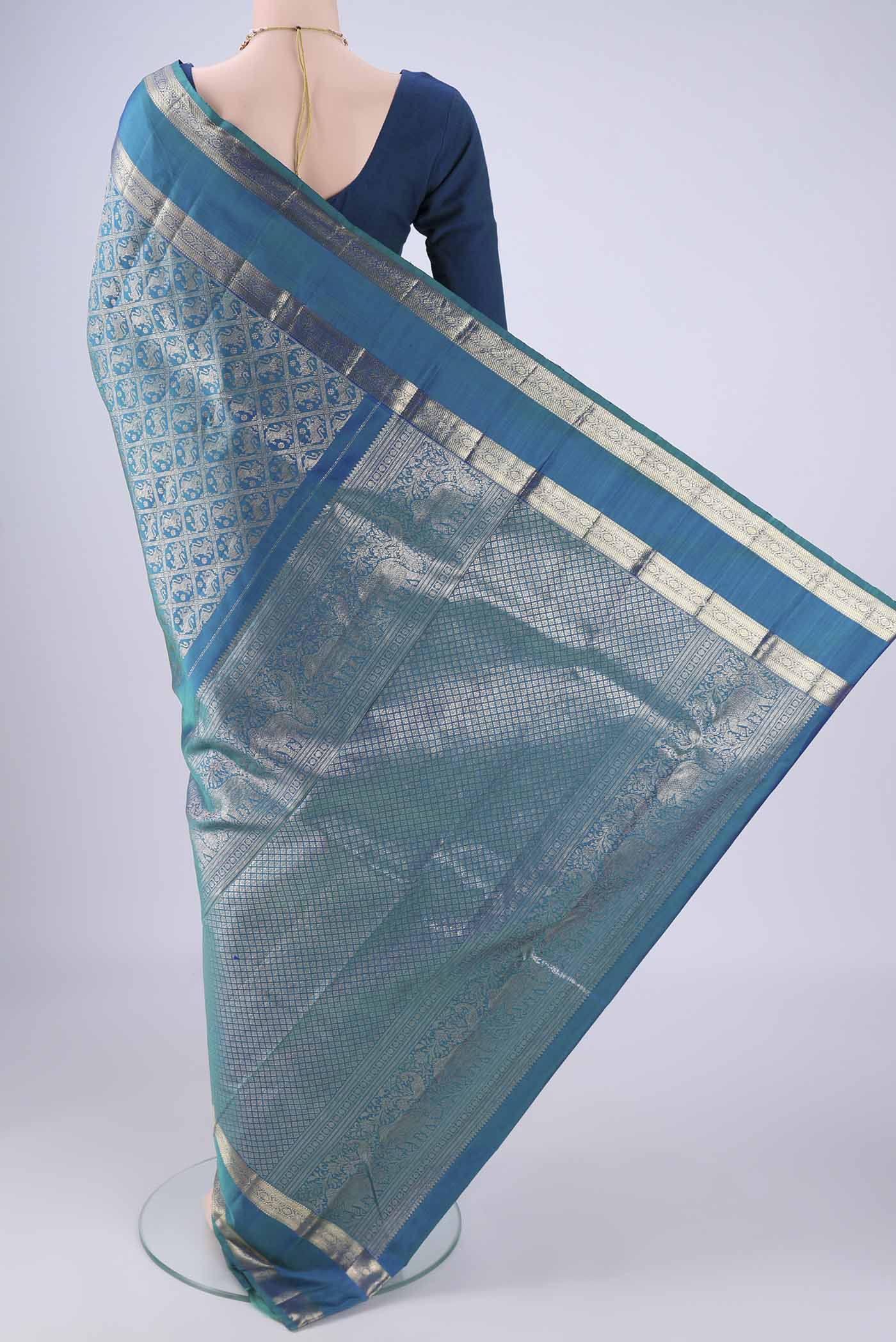 Flat view of Peacock Blue Kanchipuram Silk Saree with Zari Brocade on the body and Zari Border. 