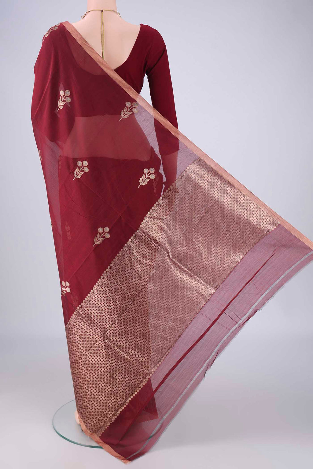 Flat view of Maroon Banarasi Kora Cotton Saree with Zari Butta on the body and Zari Border. 
