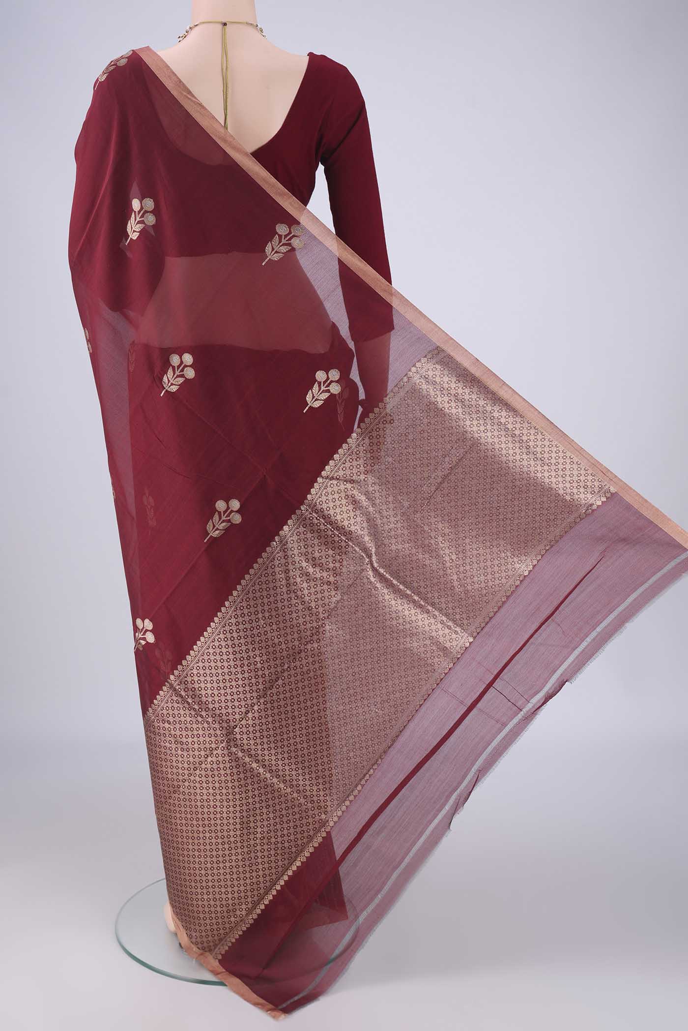 Flat view of Maroon Banarasi Kora Cotton Saree with Zari Butta on the body and Zari Border. 