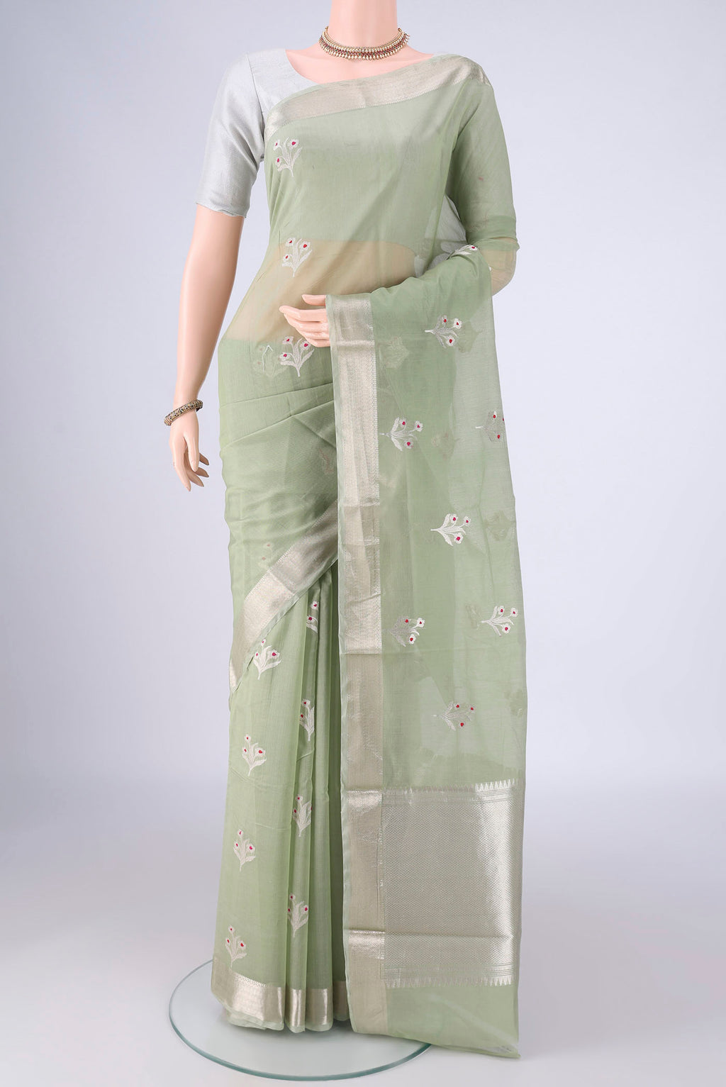 Light Green Banarasi Kora Cotton Saree with Zari Butta on the body and Zari Border.  displayed on a mannequin