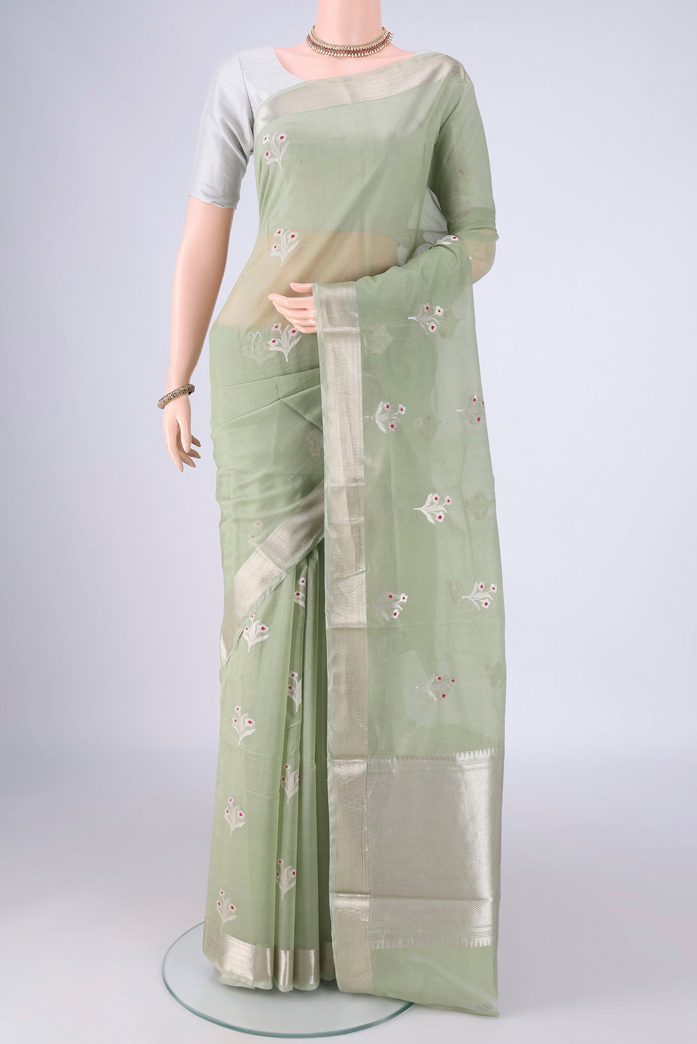 Light Green Banarasi Kora Cotton Saree with Zari Butta on the body and Zari Border.  displayed on a mannequin
