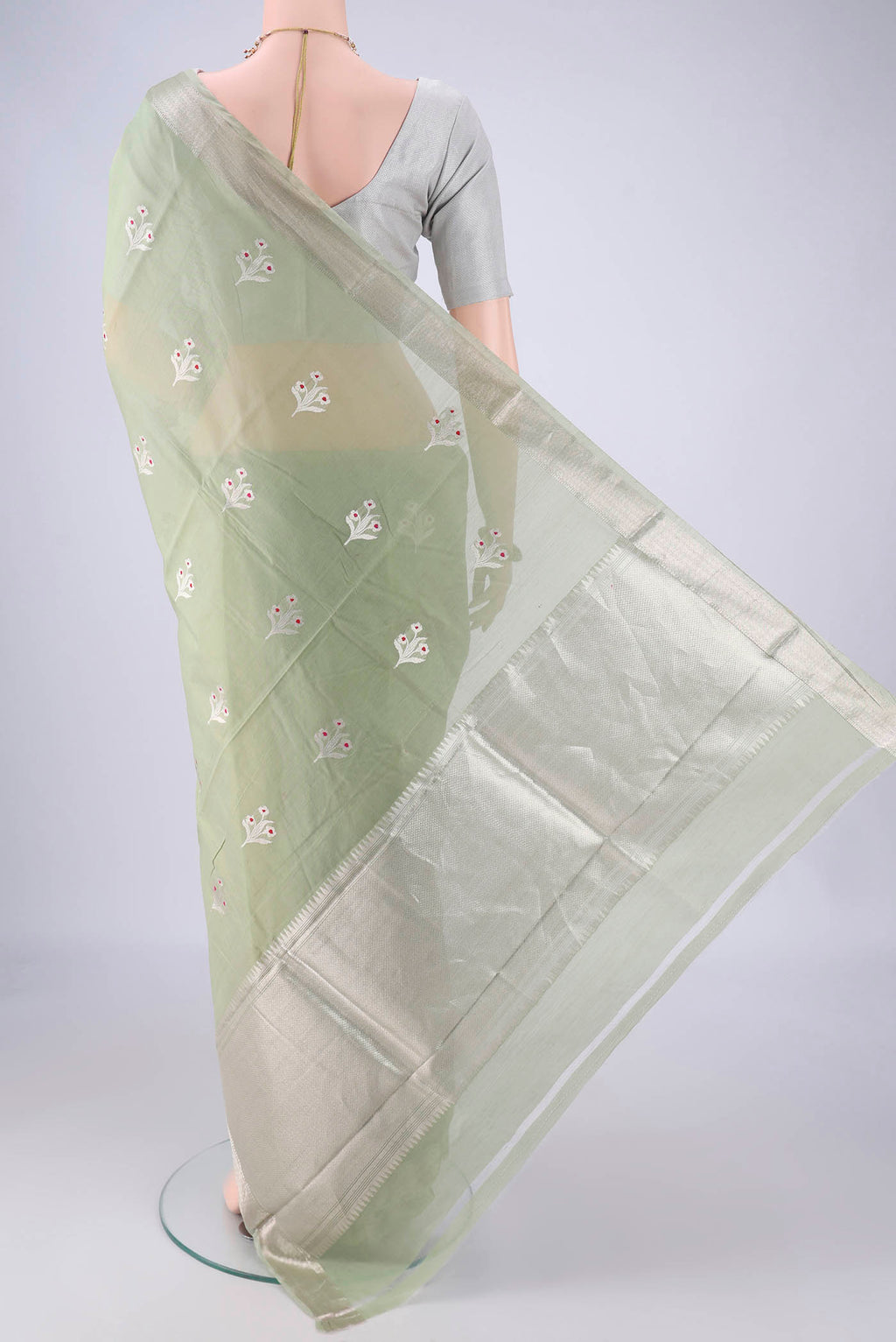 Flat view of Light Green Banarasi Kora Cotton Saree with Zari Butta on the body and Zari Border. 