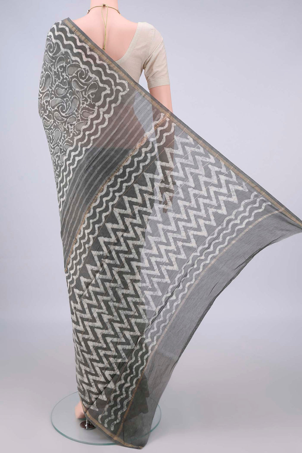 Flat view of Grey Chanderi Cotton Saree with Batik Print on the body and Thin Zari Line. 