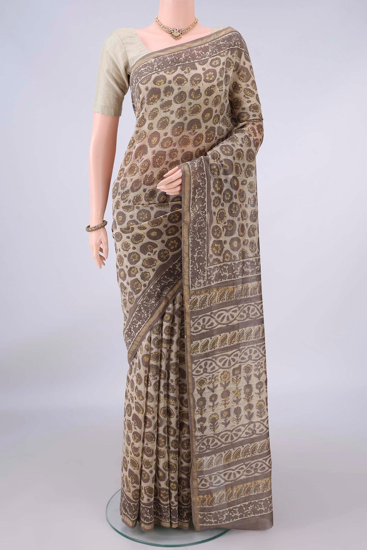 Beige Chanderi Cotton Saree with Batik Print on the body and Thin Zari Line.  displayed on a mannequin