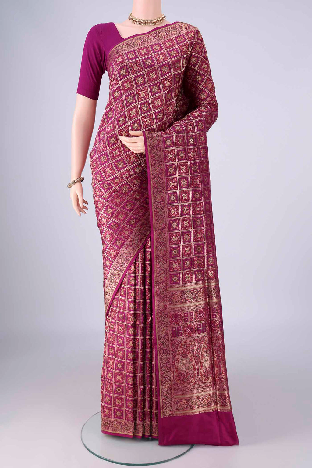 Magenta Banarasi Jamavar Saree with Checked design on the body and Zari Border.  displayed on a mannequin