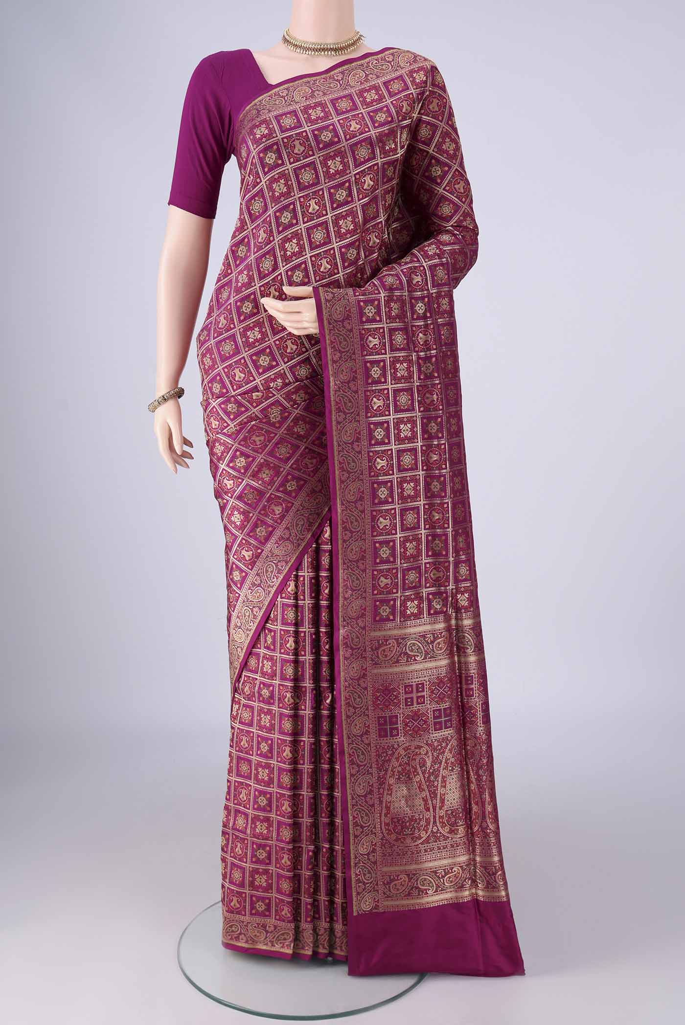 Magenta Banarasi Jamavar Saree with Checked design on the body and Zari Border.  displayed on a mannequin