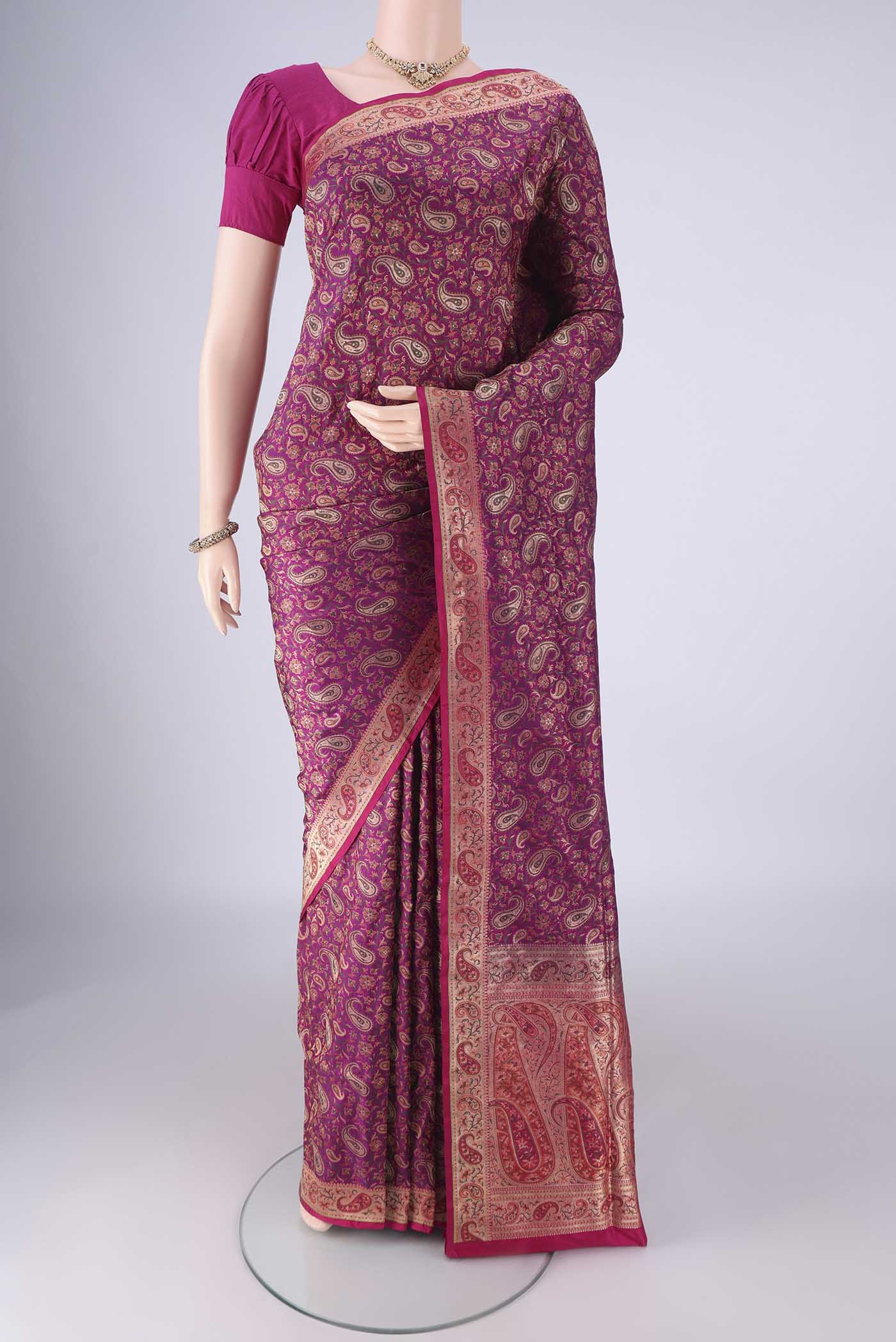 Magenta Banarasi Jamavar Saree with Jacquard design on the body and Zari Border.  displayed on a mannequin