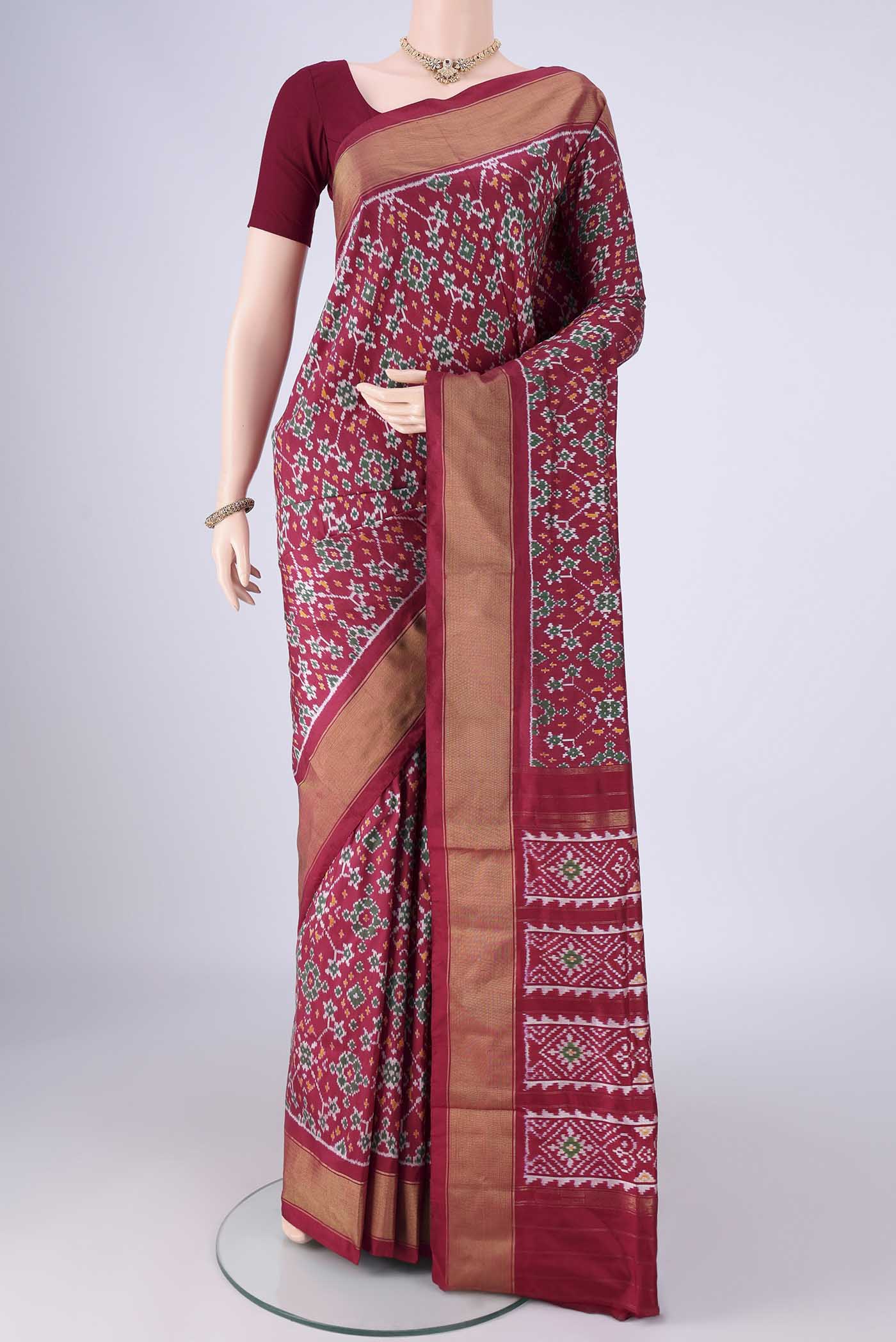 Maroon Pochampally Silk Saree with Ikat design on the body and Zari Border.  displayed on a mannequin