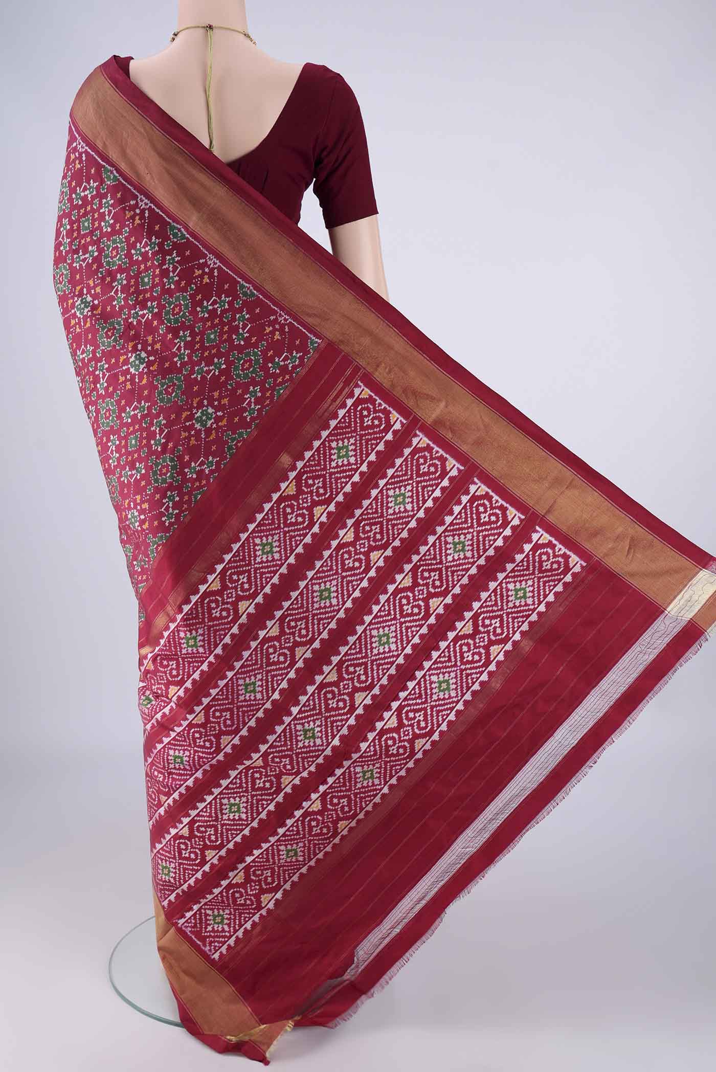 Flat view of Maroon Pochampally Silk Saree with Ikat design on the body and Zari Border. 