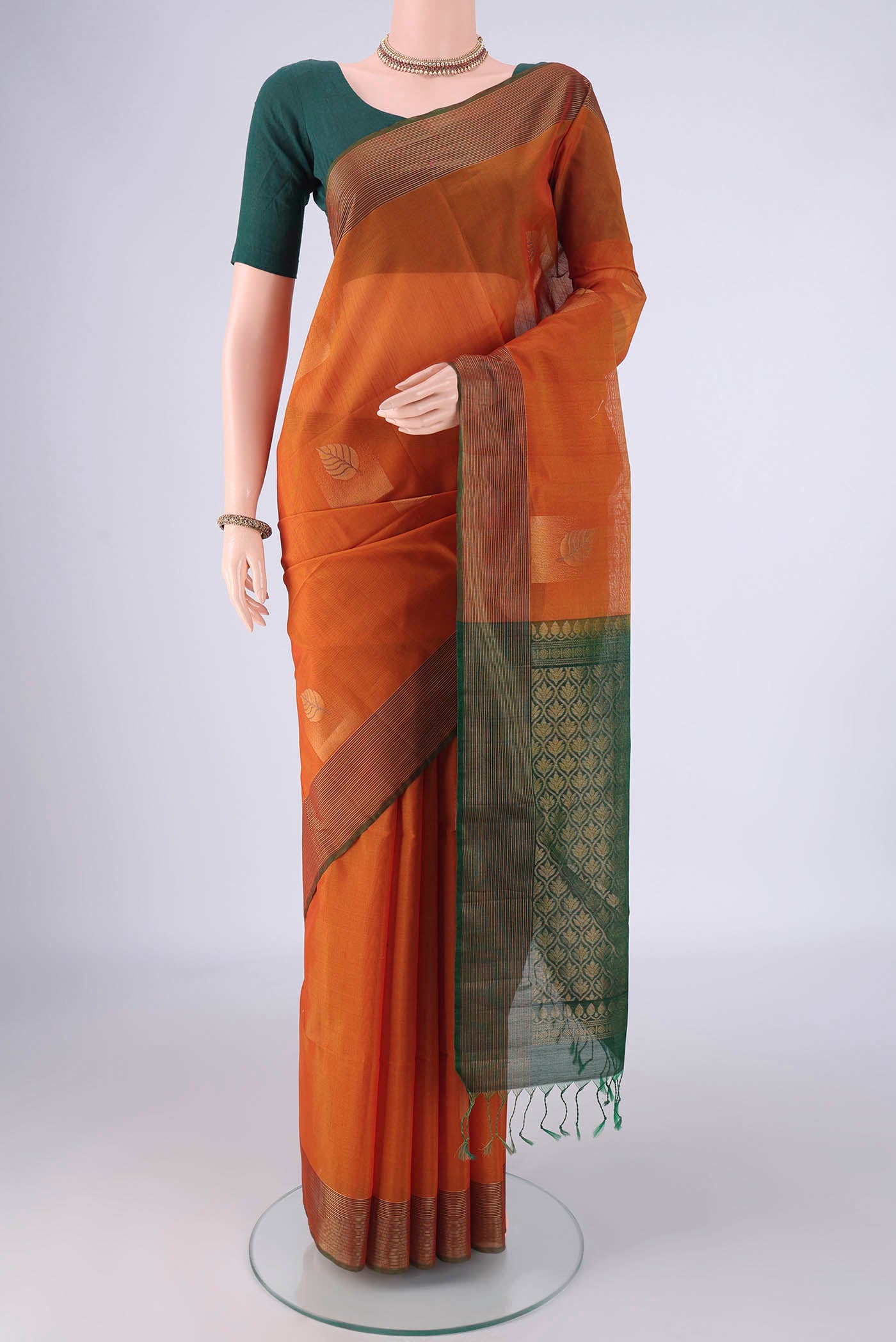 Rust Kora Cotton Saree with Zari Butta on the body and Zari Border.  displayed on a mannequin