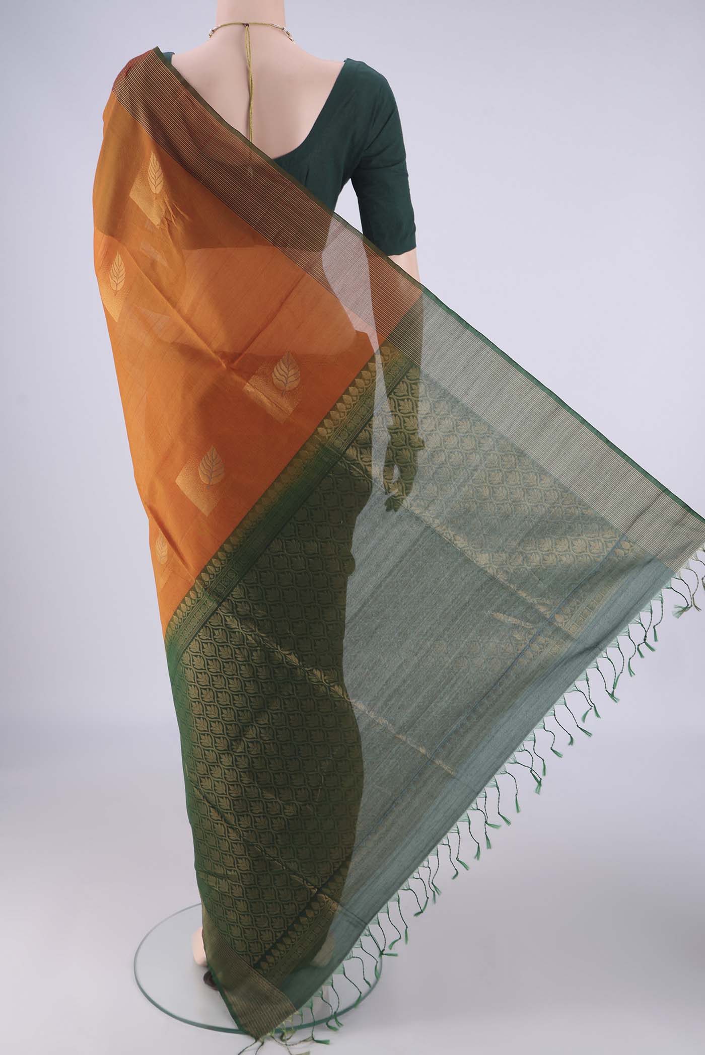Flat view of Rust Kora Cotton Saree with Zari Butta on the body and Zari Border. 