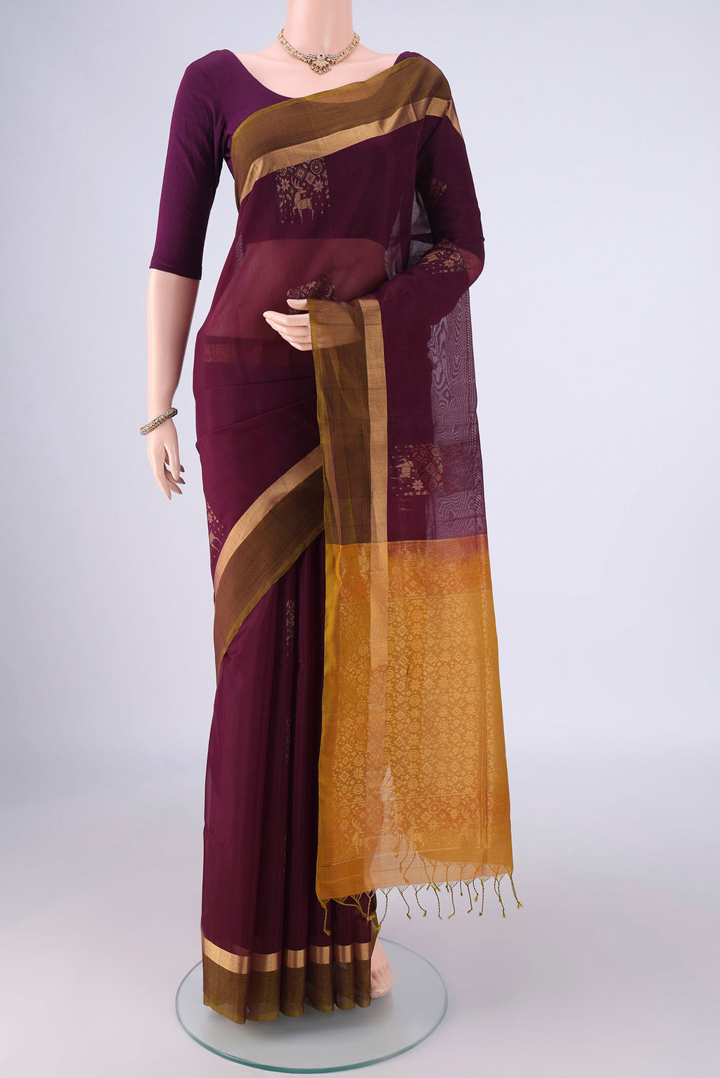 Burgundy Kora Cotton Saree with Zari Butta on the body and Zari Border.  displayed on a mannequin
