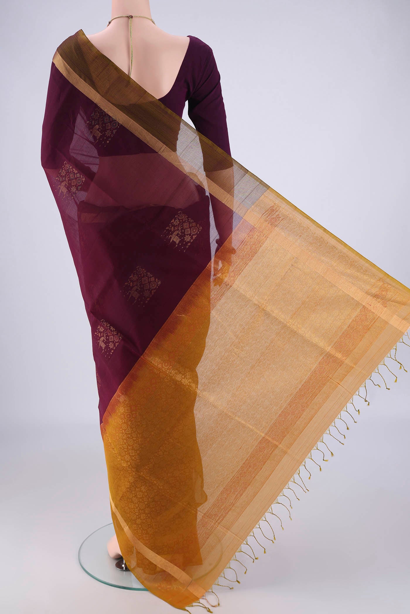 Flat view of Burgundy Kora Cotton Saree with Zari Butta on the body and Zari Border. 