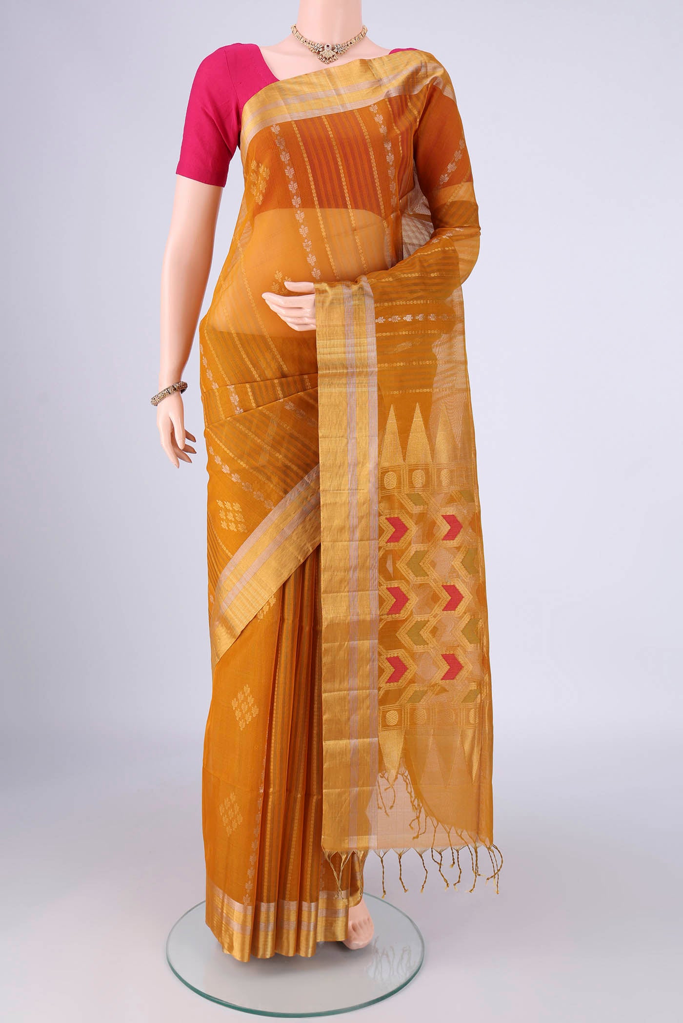Mustard Chanderi Silk Cotton Saree with Zari Butta on the body and Zari Border.  displayed on a mannequin
