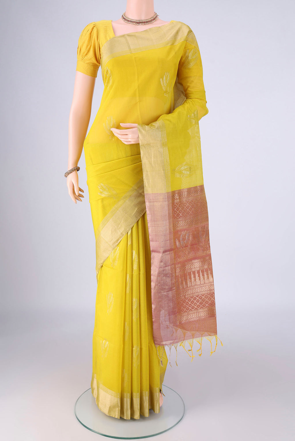 Yellow Silk Cotton Saree with Zari Butta on the body and Zari Border.  displayed on a mannequin