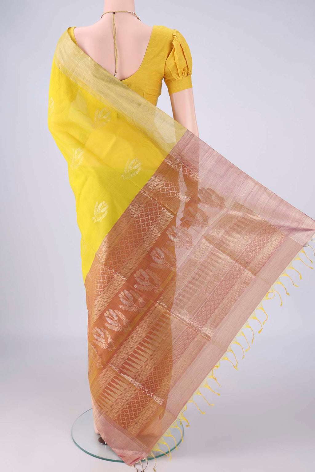 Flat view of Yellow Silk Cotton Saree with Zari Butta on the body and Zari Border. 