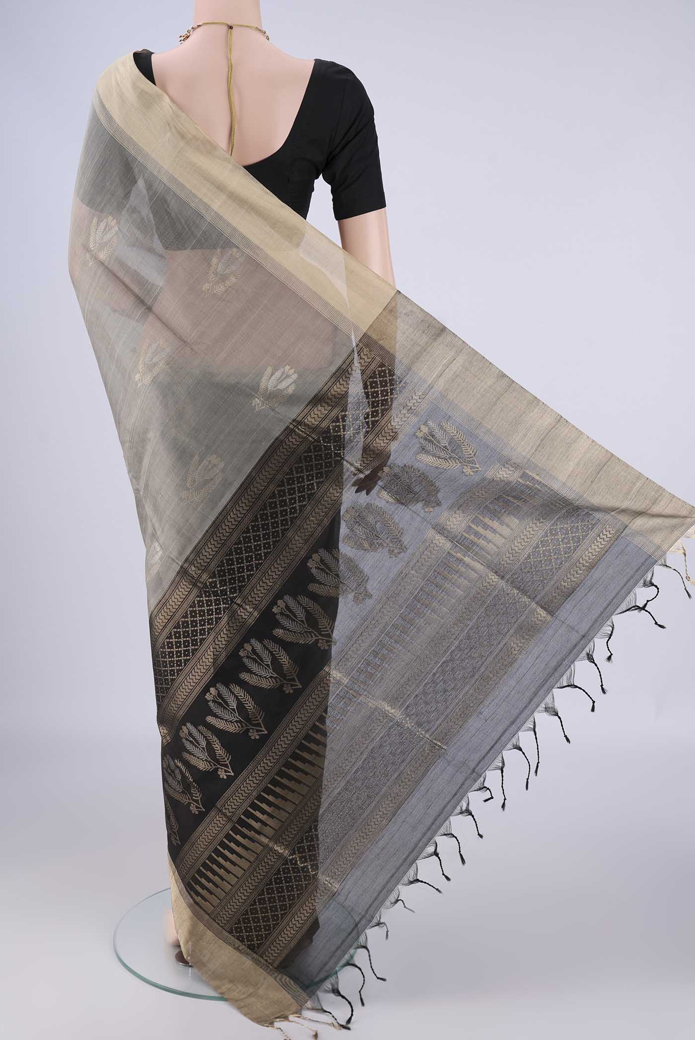 Flat view of Grey Silk Cotton Saree with Zari Butta on the body and Zari Border. 