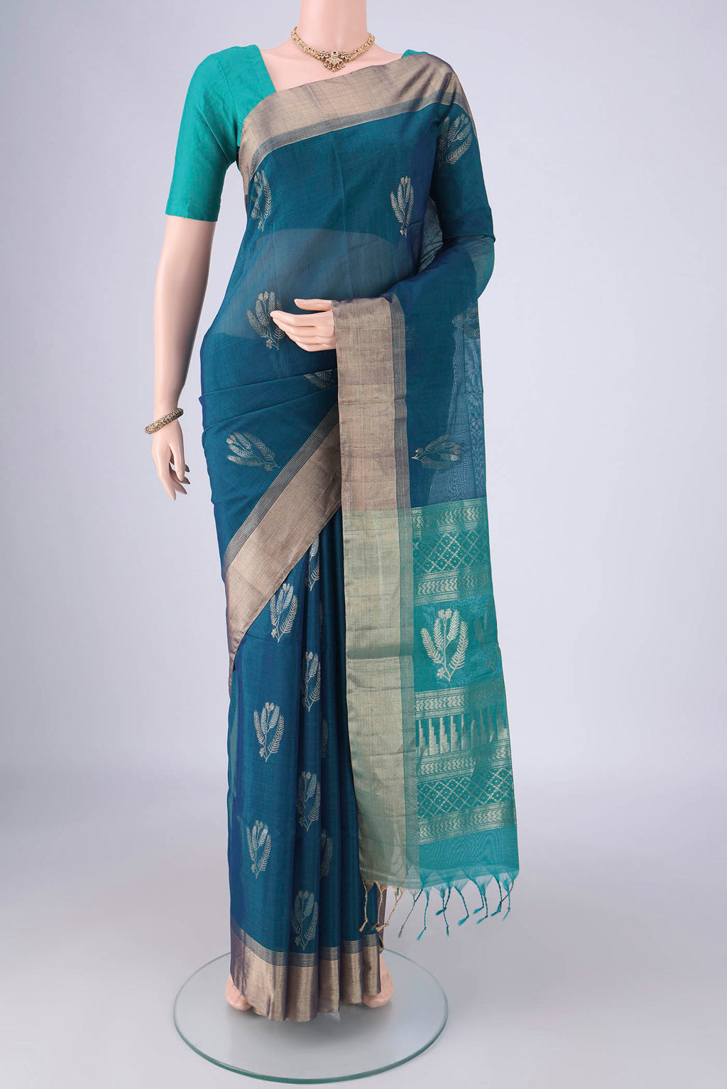 Peacock Blue Kora Cotton Saree with Zari Butta on the body and Zari Border.  displayed on a mannequin