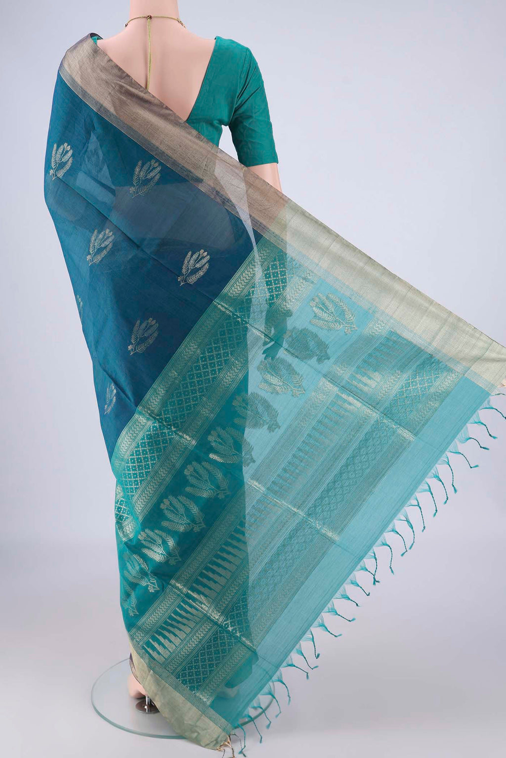 Flat view of Peacock Blue Kora Cotton Saree with Zari Butta on the body and Zari Border. 