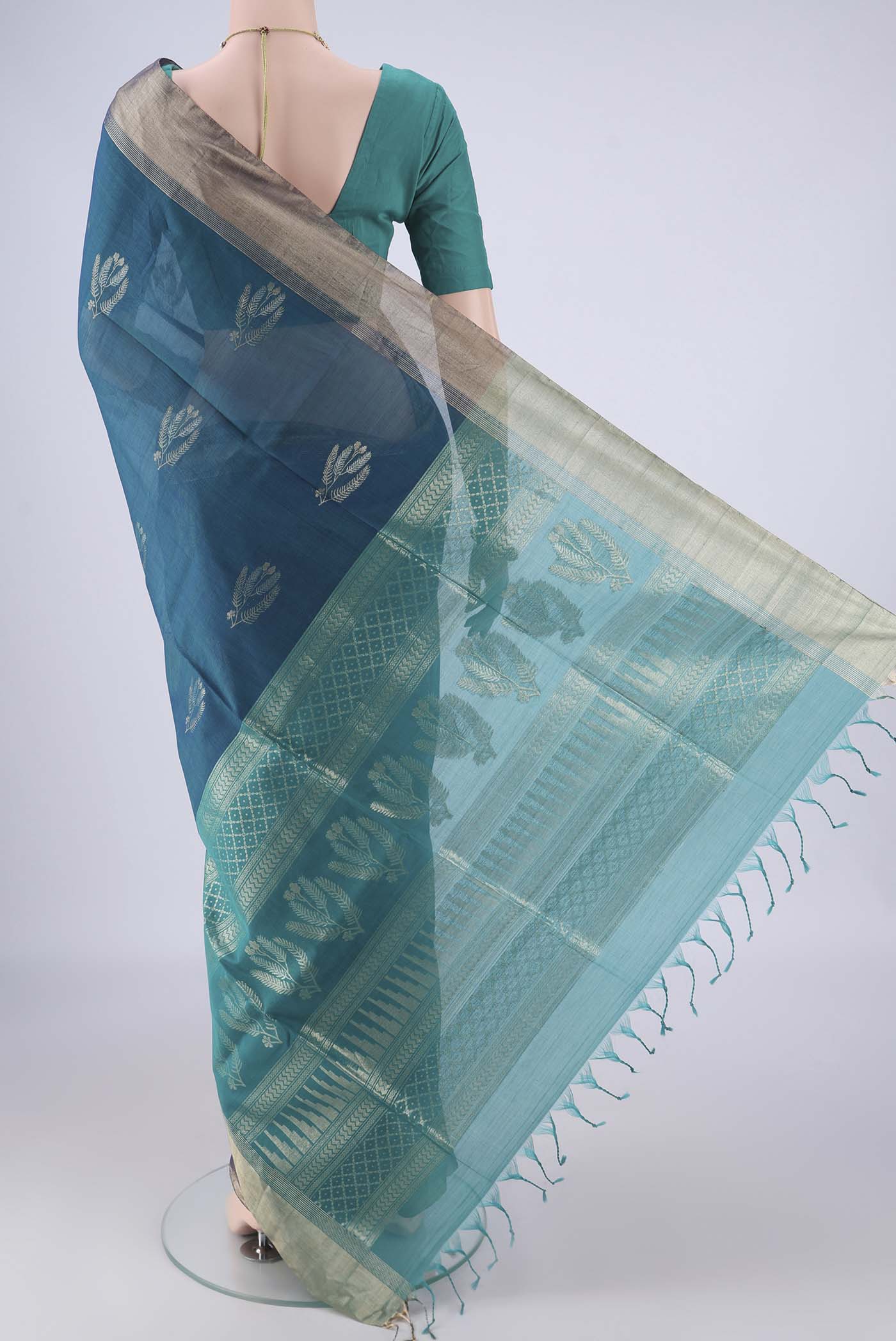 Flat view of Peacock Blue Kora Cotton Saree with Zari Butta on the body and Zari Border. 