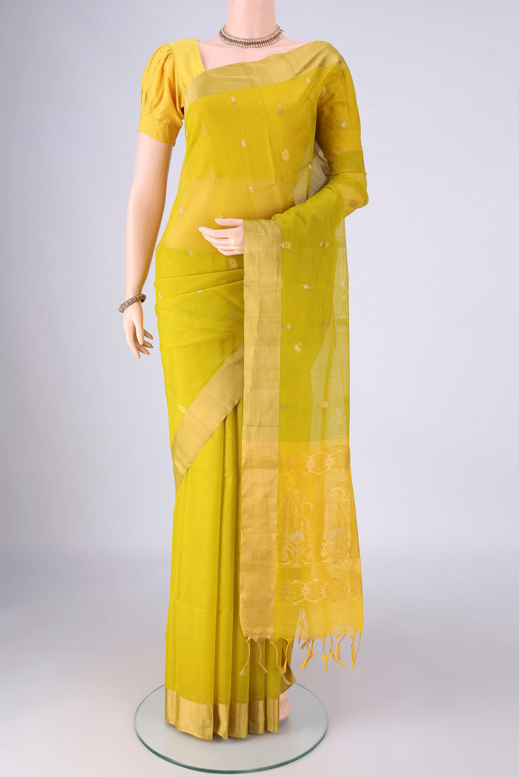 Acid Green Silk Cotton Saree with Zari Butta on the body and Zari Border.  displayed on a mannequin