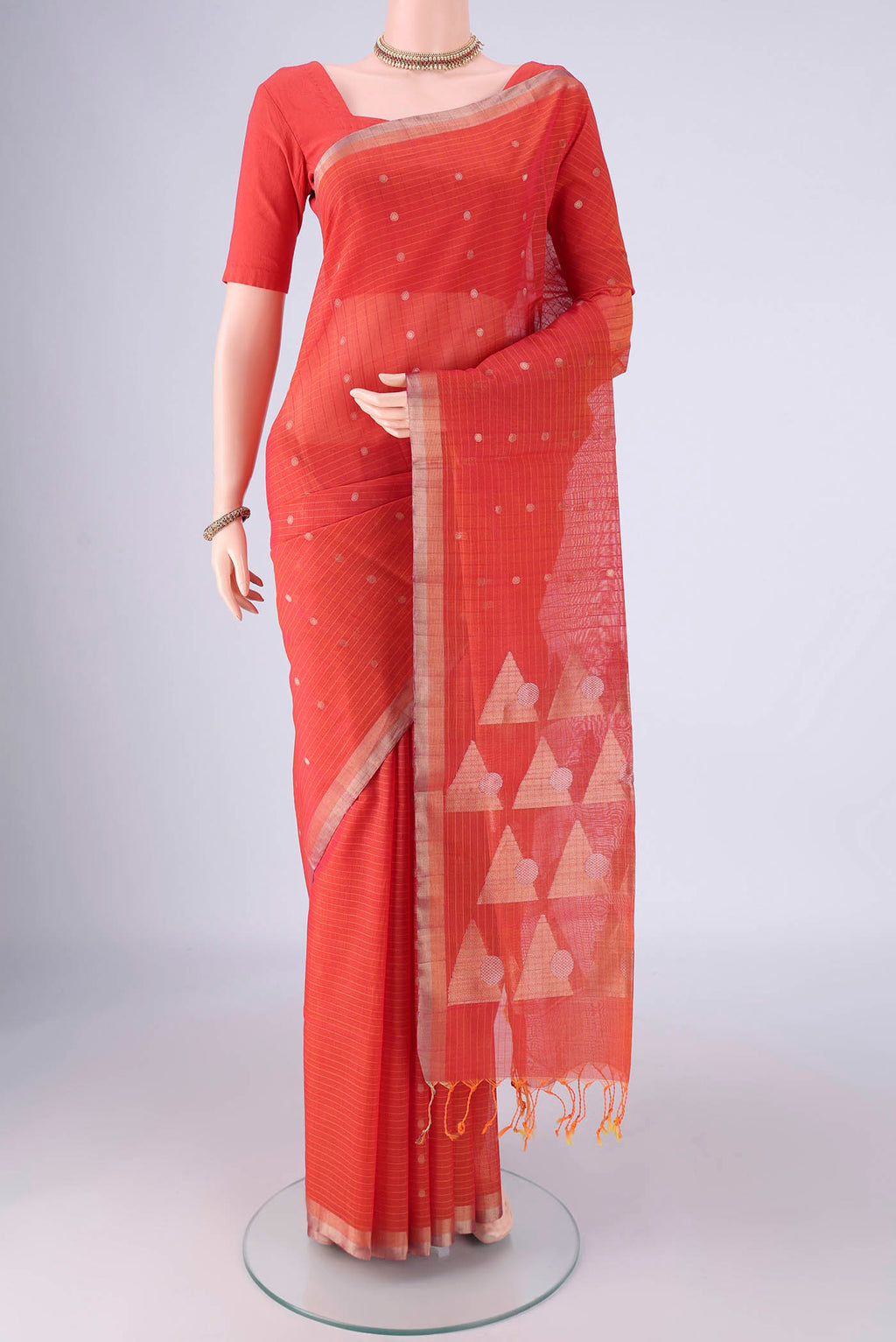 Orange Silk Cotton Saree with Zari Butta on the body and Zari Border.  displayed on a mannequin
