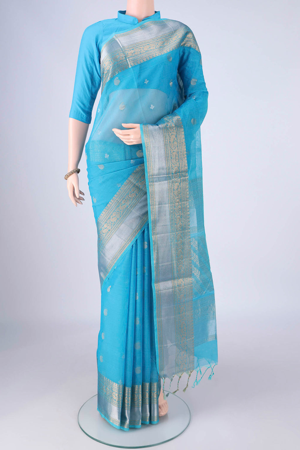 Sky Blue Silk Cotton Saree with Zari Butta on the body and Zari Border.  displayed on a mannequin