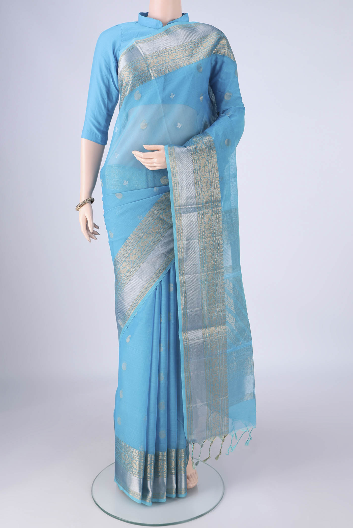 Sky Blue Silk Cotton Saree with Zari Butta on the body and Zari Border.  displayed on a mannequin