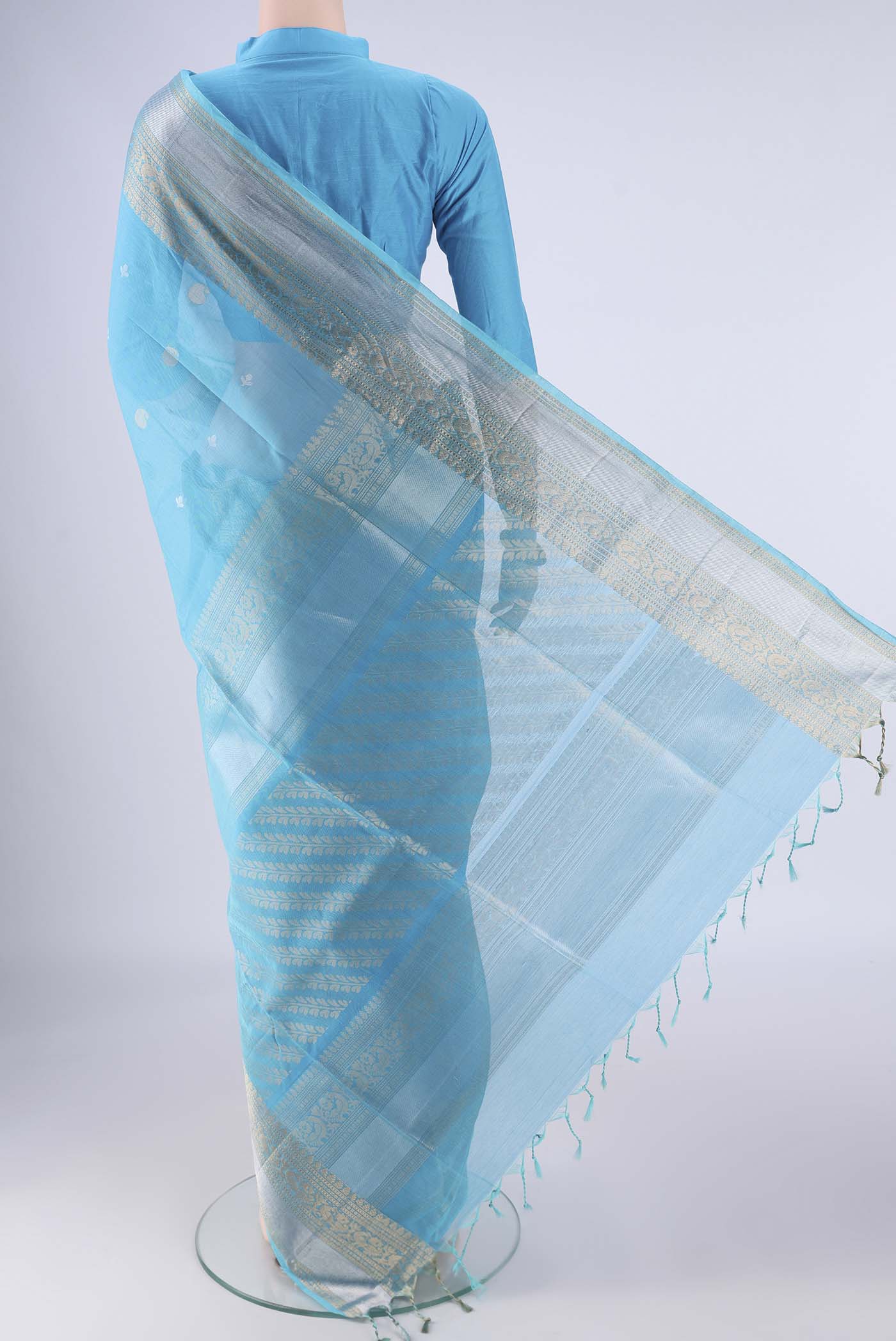 Flat view of Sky Blue Silk Cotton Saree with Zari Butta on the body and Zari Border. 