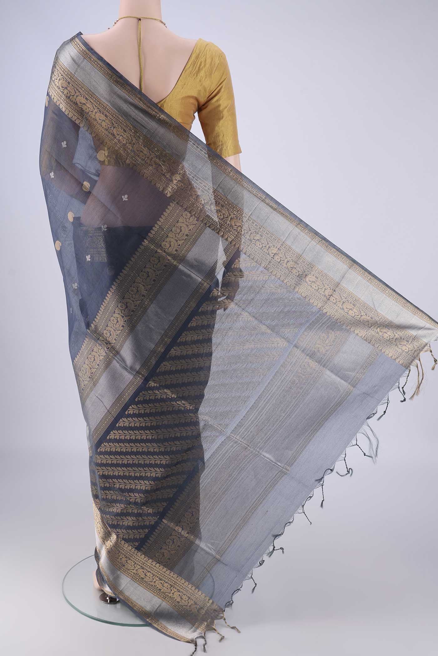 Flat view of Blue Grey Silk Cotton Saree with Zari Butta on the body and Zari Border. 