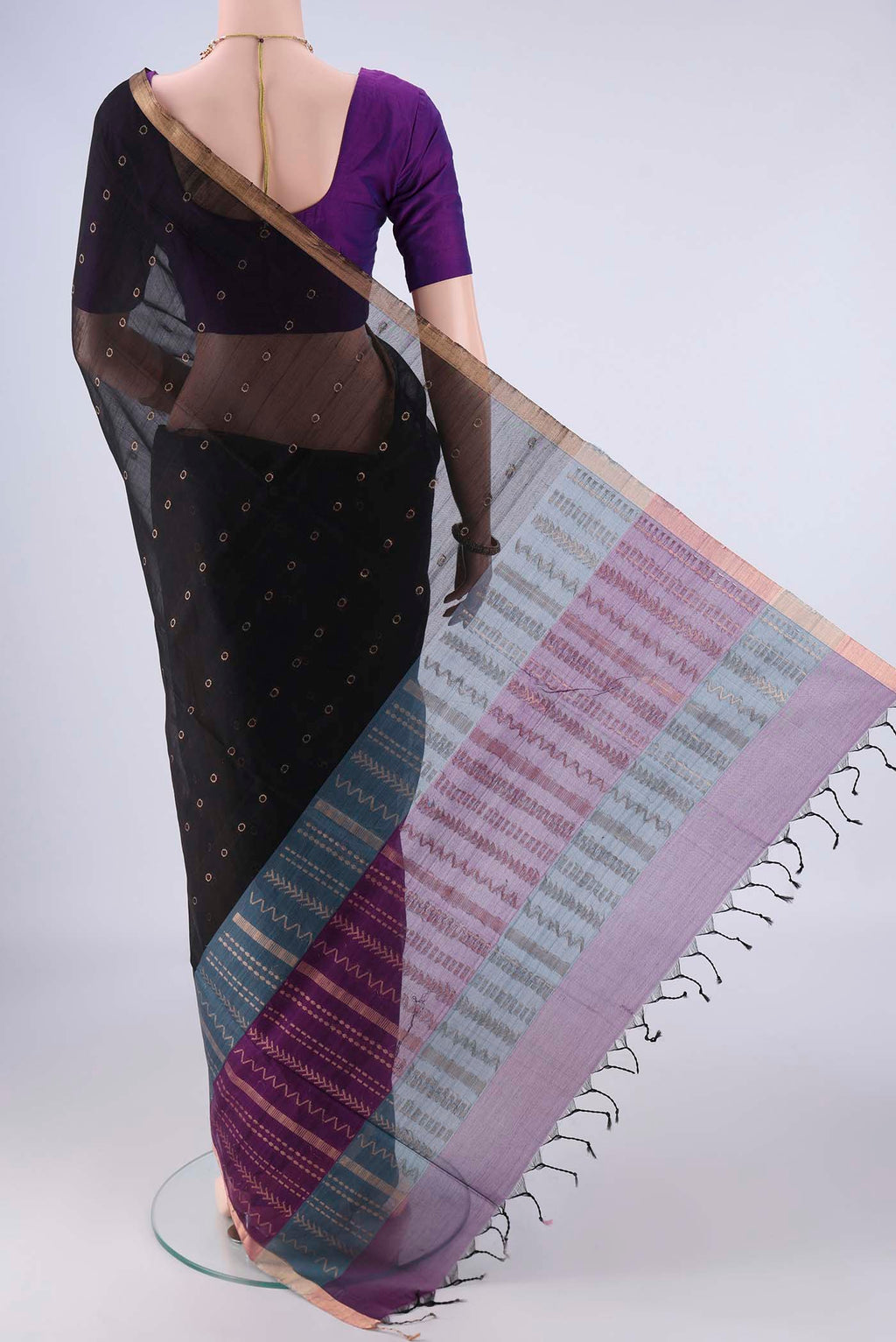 Flat view of Black Silk Cotton Saree with Zari And Thread Butta on the body and Zari Border. 