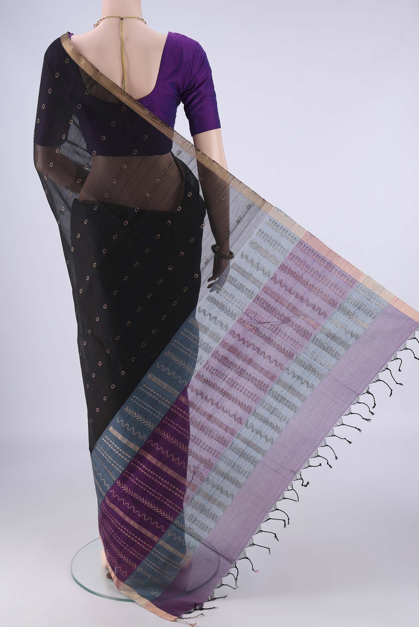 Flat view of Black Silk Cotton Saree with Zari And Thread Butta on the body and Zari Border. 