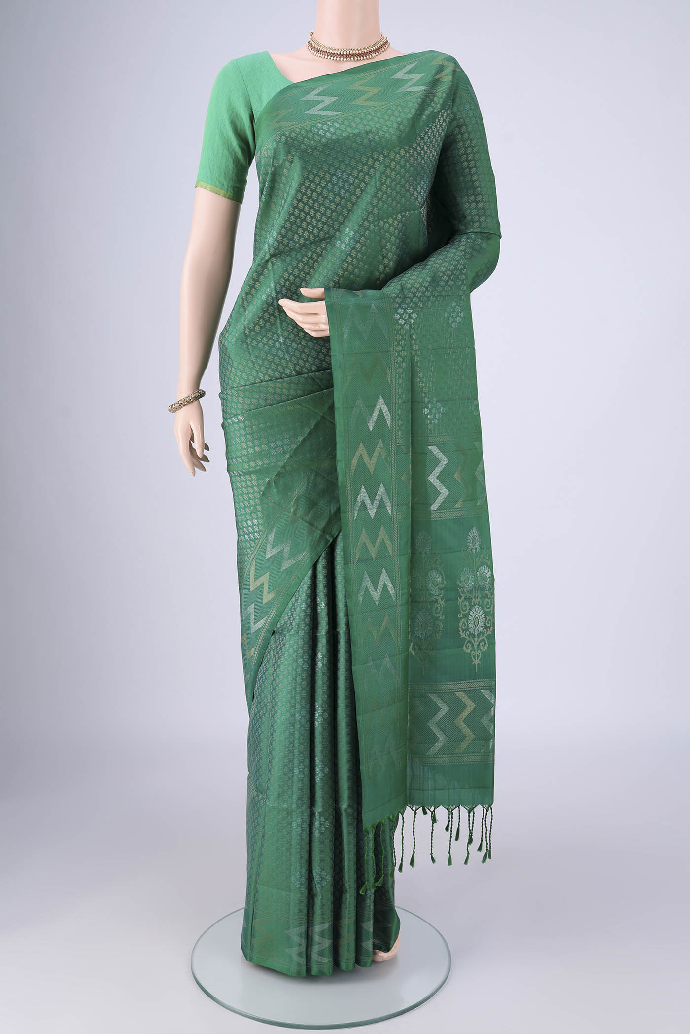 Green Soft Silk Saree with Zari Brocade on the body and Zari Border.  displayed on a mannequin