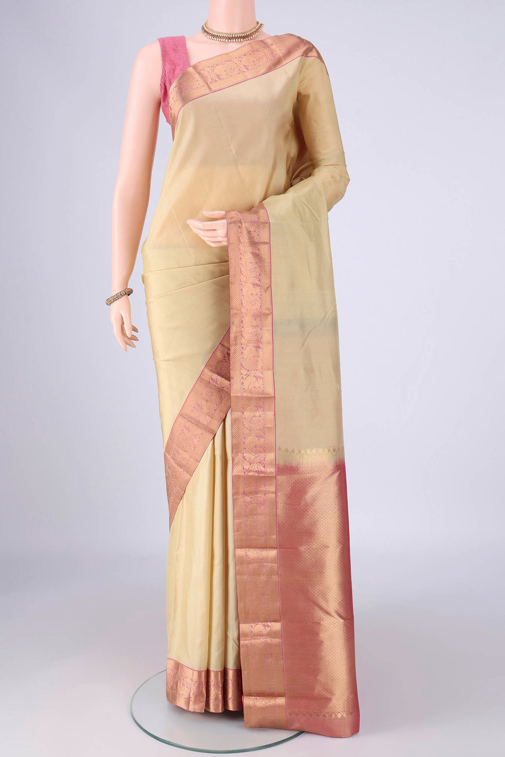 Beige Kanjivaram Silk Saree with Zari Butta on the body and Zari Border.  displayed on a mannequin