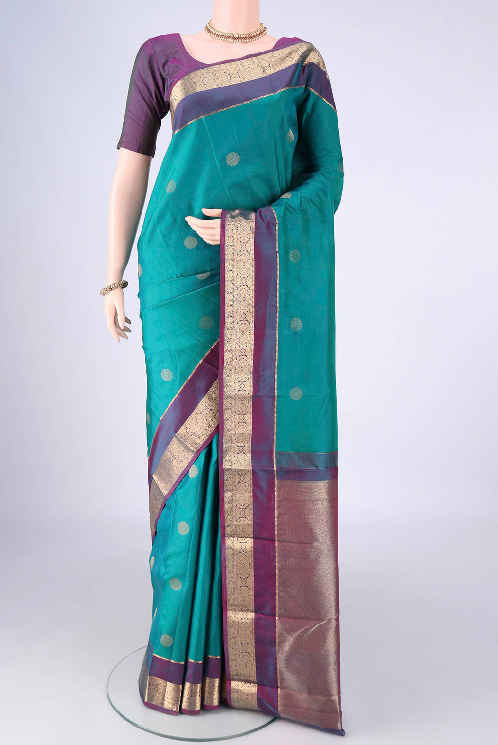 Sea Green Kanchipuram Silk Saree with Zari Butta on the body and Zari Border.  displayed on a mannequin