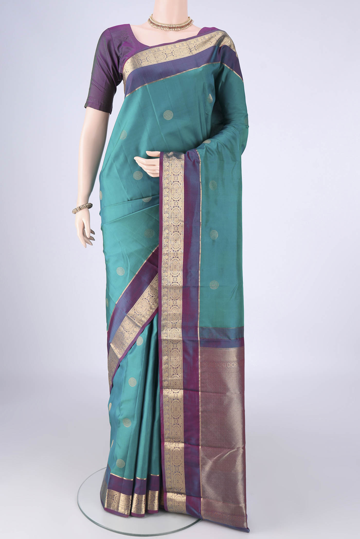Sea Green Kanchipuram Silk Saree with Zari Butta on the body and Zari Border.  displayed on a mannequin