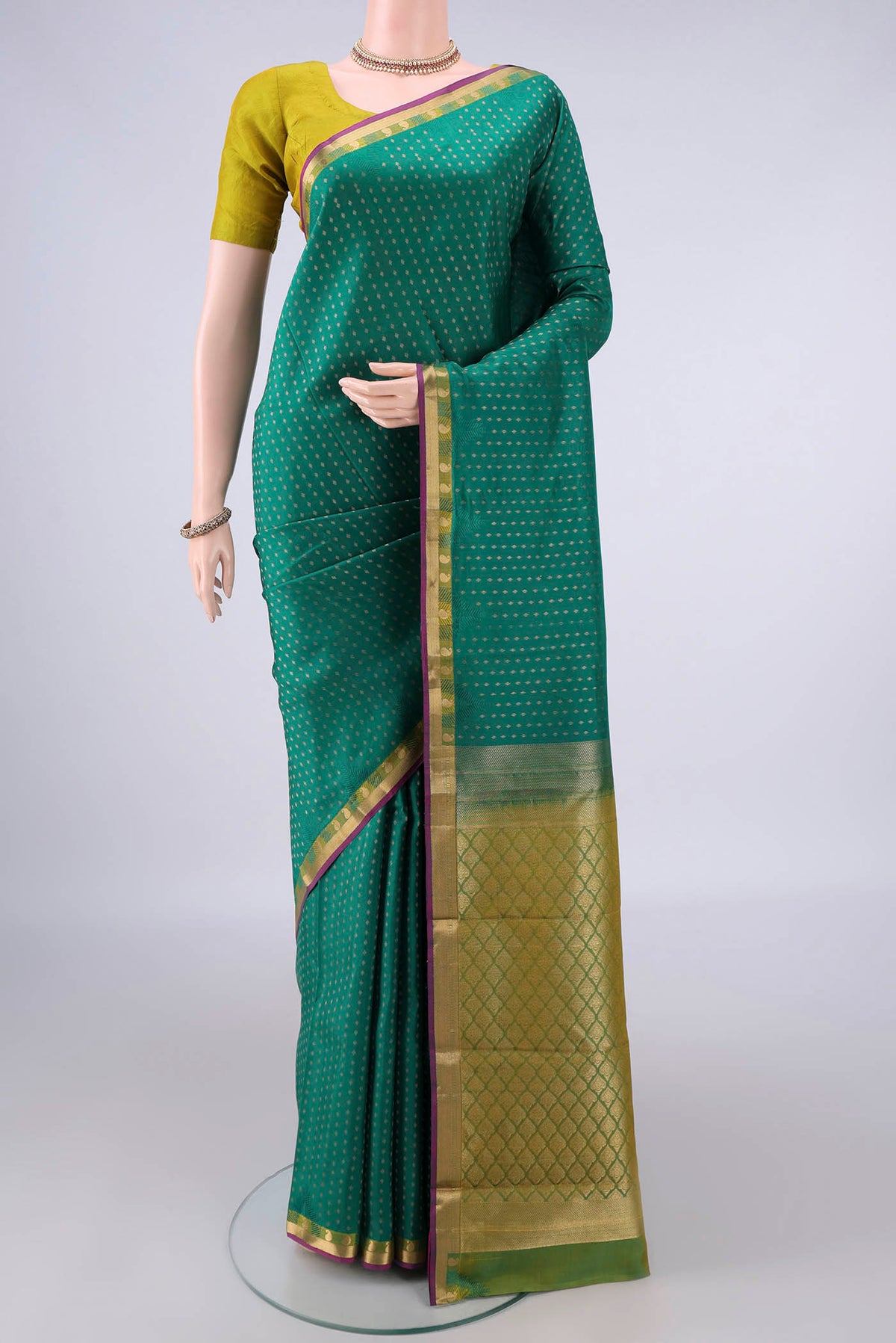Pure Silk Green Kanchipuram Saree with Zari Butta on the body and Zari Border.  displayed on a mannequin