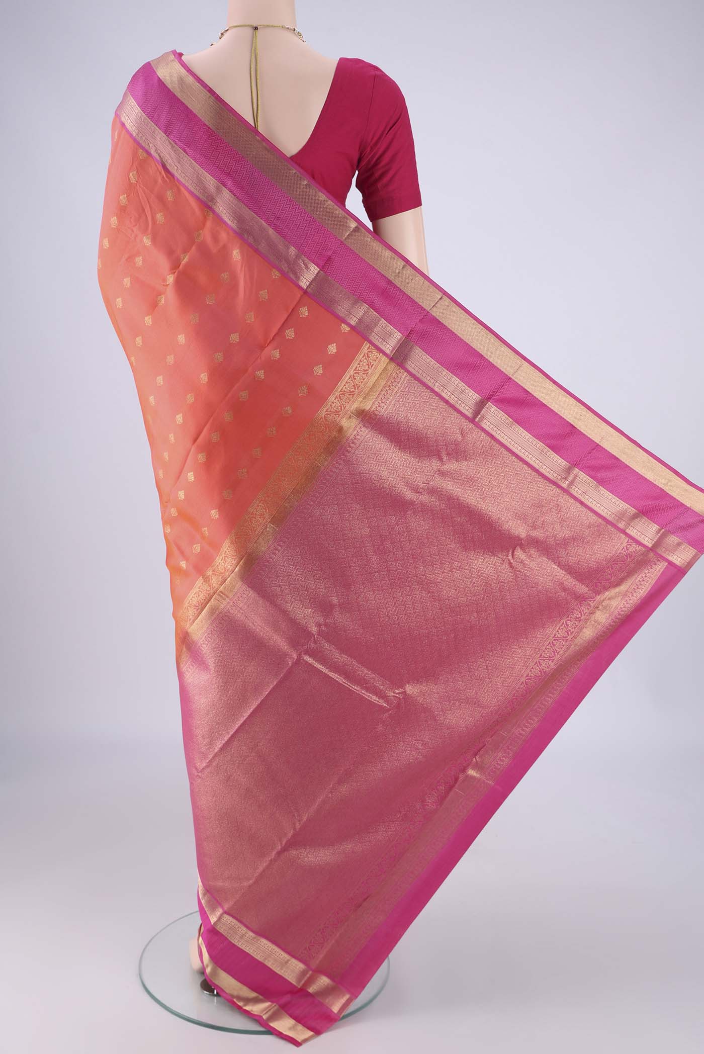 Flat view of Orange Kanchipuram Silk Saree with Zari Butta on the body and Zari Border. 