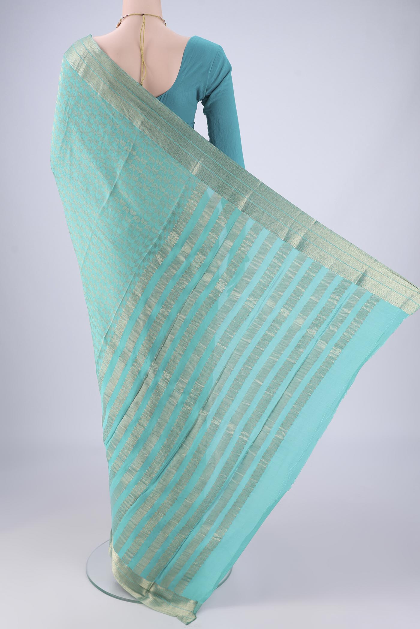Flat view of Turquoise Mysore Crepe Saree with Zari Brocade on the body and Zari Border. 