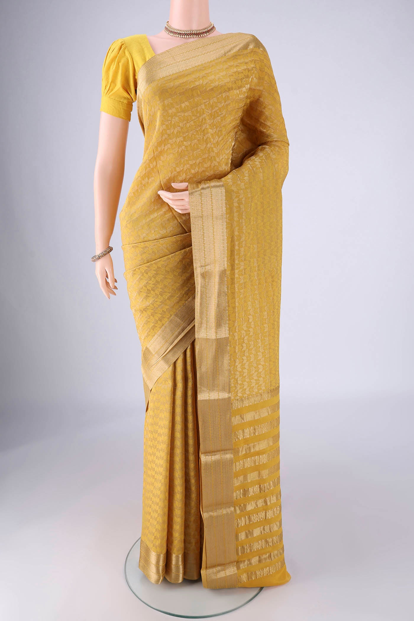 Yellow Mysore Crepe Saree with Zari Brocade on the body and Zari Border.  displayed on a mannequin